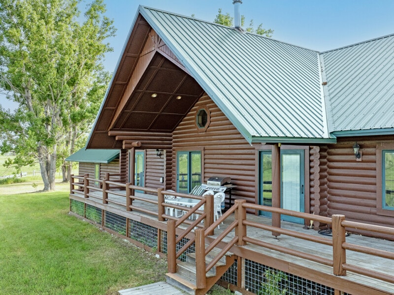 Peaked roof with this log home with large deck